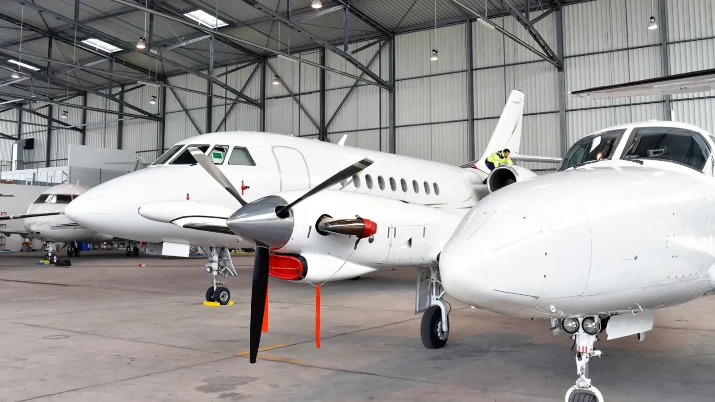 Business aircraft parked inside a large hangar
