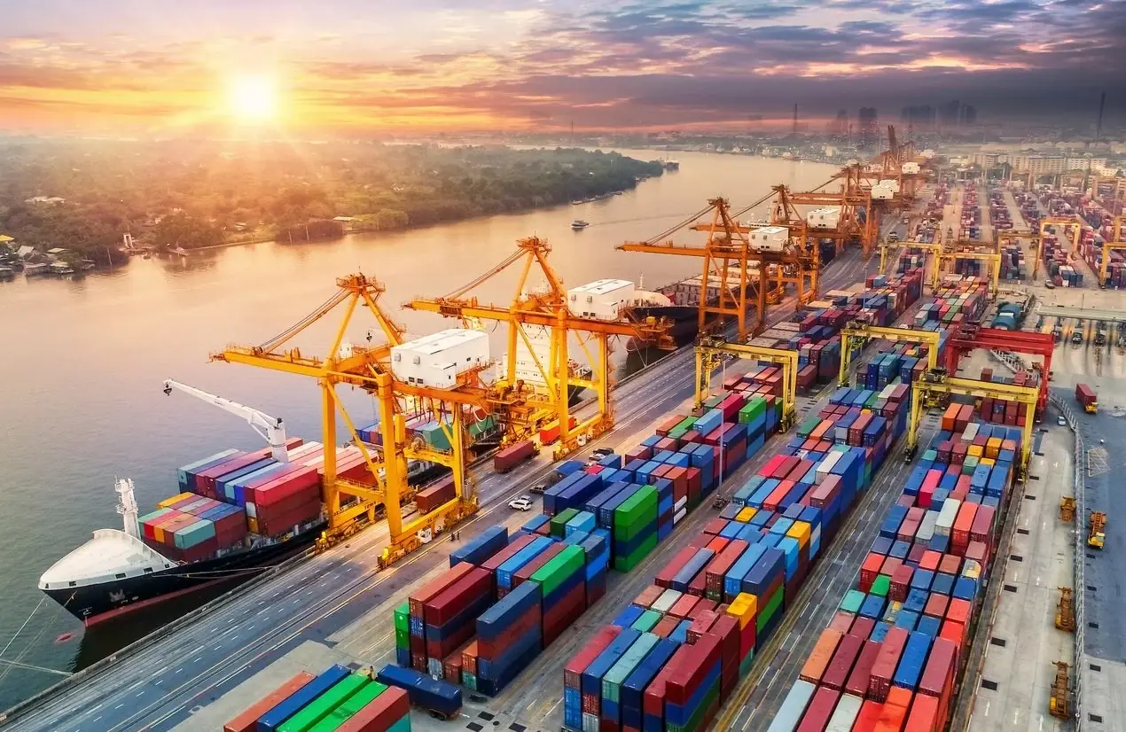 Container port and cargo vessels in warm sunset light
